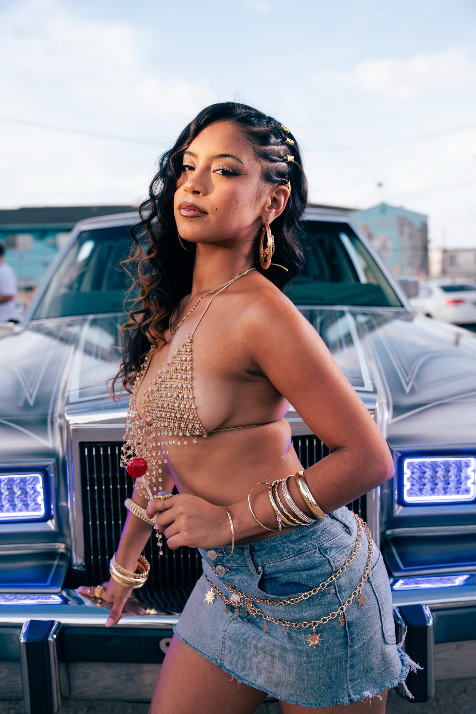 Model in front of a silver Lincoln lowrider grille with glowing blue custom headlights