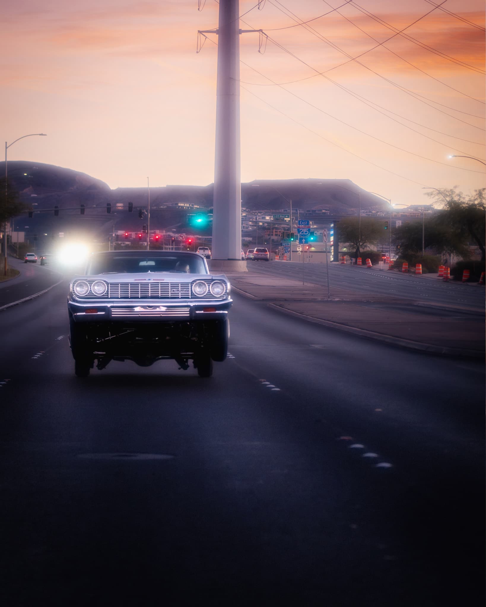 Lowrider Impala hitting 3-wheel on a Las Vegas highway at sunset with mountains in background - mkegzy Photography
