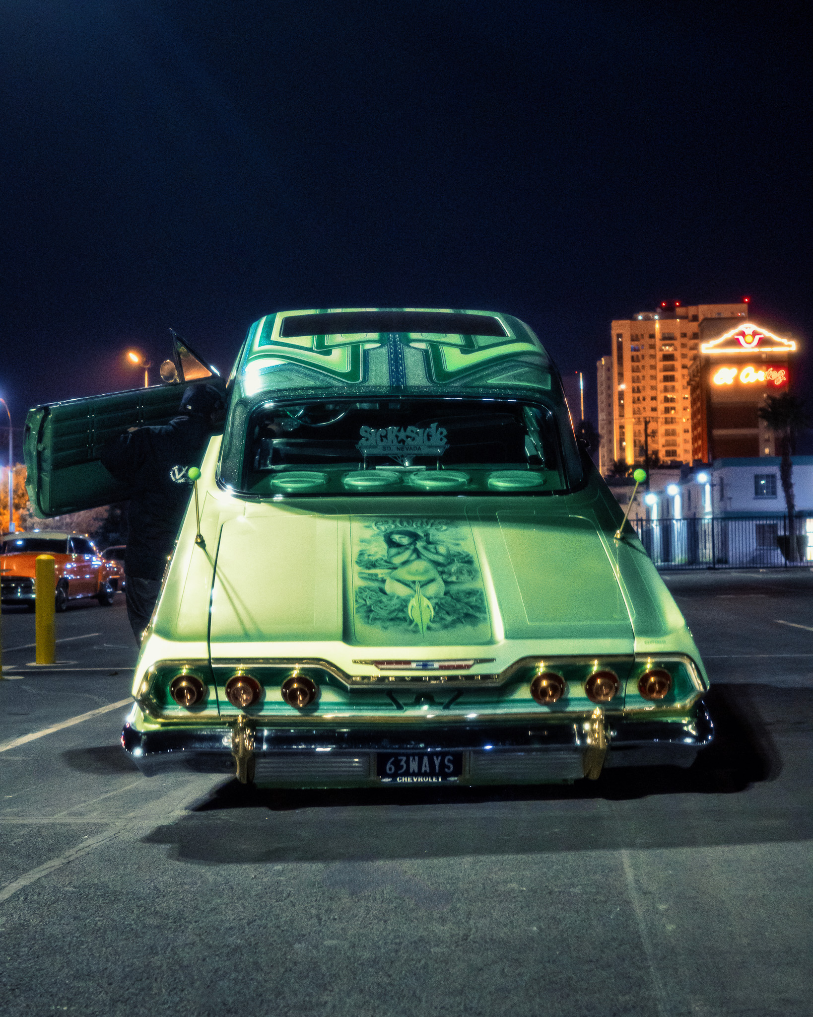 Signature green Chevrolet Impala lowrider night scene with neon lighting